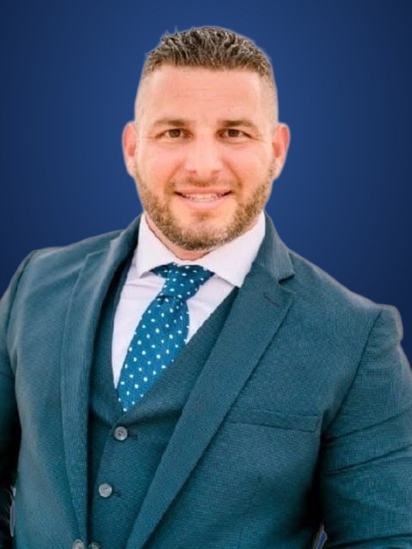 George Schembri III in a teal suit and blue tie